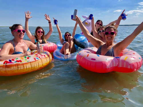 Ladies celebrating with friends in the water.